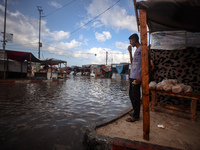 A Palestinian boy walks in a puddle in rainy weather at a camp for displaced people in Khan Yunis, Gaza Strip, on September 22, 2024, amid t...