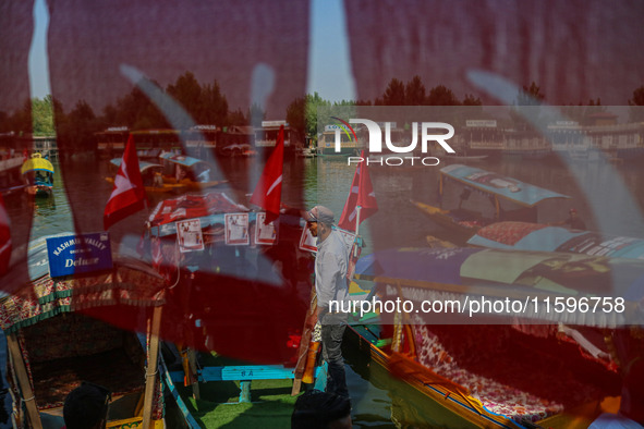 Supporters of the Jammu and Kashmir National Conference party (JKNC) install the party's flag on boats during an election rally at Dal Lake,...