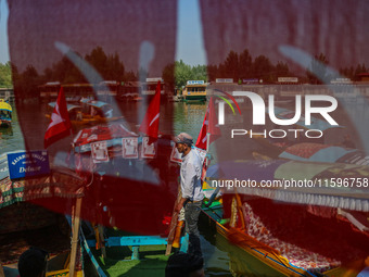 Supporters of the Jammu and Kashmir National Conference party (JKNC) install the party's flag on boats during an election rally at Dal Lake,...