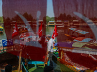 Supporters of the Jammu and Kashmir National Conference party (JKNC) install the party's flag on boats during an election rally at Dal Lake,...