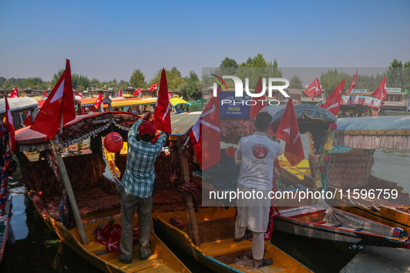 Supporters of the Jammu and Kashmir National Conference party (JKNC) install the party's flag on boats during an election rally at Dal Lake,...