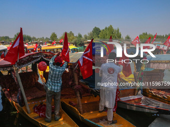 Supporters of the Jammu and Kashmir National Conference party (JKNC) install the party's flag on boats during an election rally at Dal Lake,...