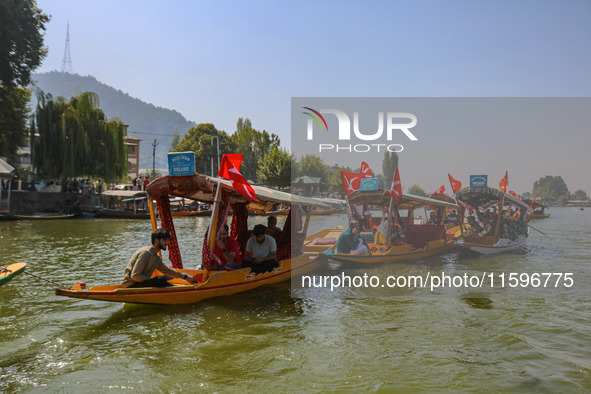 Supporters of the Jammu and Kashmir National Conference party (JKNC) participate in an election rally at Dal Lake, ahead of the second phase...