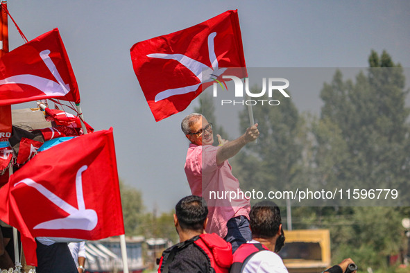 Omar Abdullah, the leader of Jammu and Kashmir National Conference (JKNC), poses with his party's flag during an election rally at Dal Lake,...