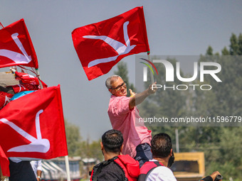 Omar Abdullah, the leader of Jammu and Kashmir National Conference (JKNC), poses with his party's flag during an election rally at Dal Lake,...