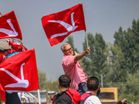 Omar Abdullah, the leader of Jammu and Kashmir National Conference (JKNC), poses with his party's flag during an election rally at Dal Lake,...