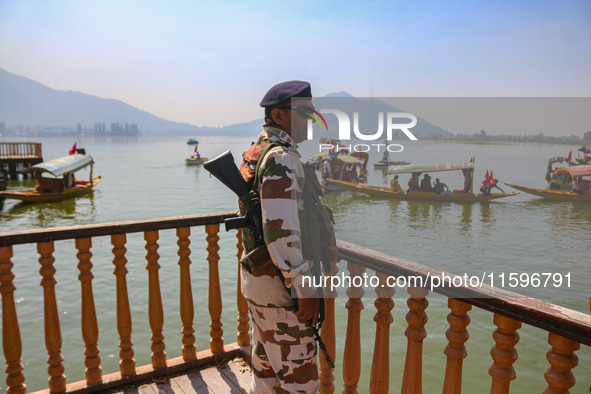 An Indian security personnel stands guard during an election rally at Dal Lake, ahead of the second phase of voting during the assembly elec...