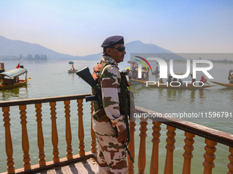 An Indian security personnel stands guard during an election rally at Dal Lake, ahead of the second phase of voting during the assembly elec...