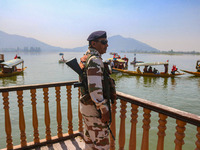 An Indian security personnel stands guard during an election rally at Dal Lake, ahead of the second phase of voting during the assembly elec...