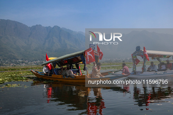 Supporters of the Jammu and Kashmir National Conference party (JKNC) participate in an election rally at Dal Lake, ahead of the second phase...