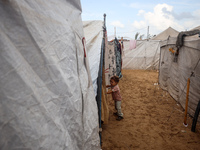 A Palestinian boy looks out from his tent in the Al-Mawasi area in Khan Yunis in the southern Gaza Strip on September 22, 2024, amid the ong...