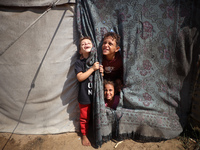 Displaced Palestinian children look out from their tent in the Mawasi area in Khan Younis, southern Gaza Strip, on September 22, 2024, amid...