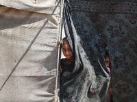 Displaced Palestinian children look out from their tent in the Mawasi area in Khan Younis, southern Gaza Strip, on September 22, 2024, amid...