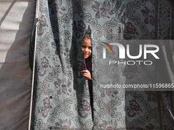 A Palestinian boy looks out from his tent in the Al-Mawasi area in Khan Yunis in the southern Gaza Strip on September 22, 2024, amid the ong...