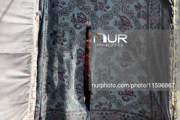 A Palestinian boy looks out from his tent in the Al-Mawasi area in Khan Yunis in the southern Gaza Strip on September 22, 2024, amid the ong...