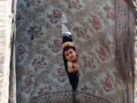 A Palestinian boy looks out from his tent in the Al-Mawasi area in Khan Yunis in the southern Gaza Strip on September 22, 2024, amid the ong...