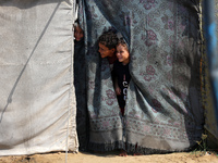 Displaced Palestinian children look out from their tent in the Mawasi area in Khan Younis, southern Gaza Strip, on September 22, 2024, amid...