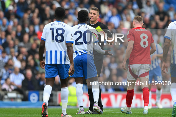 Referee Robert Jones shows a yellow card to Carlos Baleba of Brighton during the Premier League match between Brighton and Hove Albion and N...