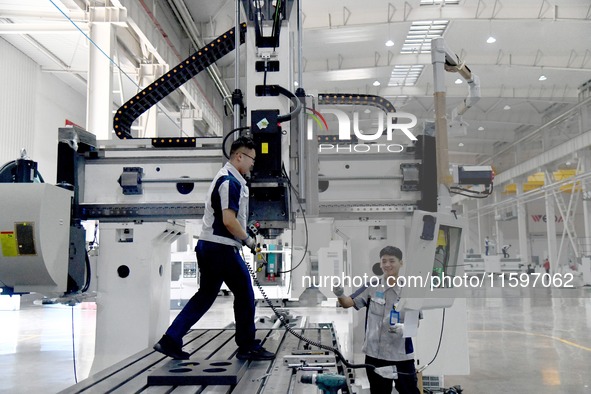 An employee debuts a CNC machine tool at an intelligent equipment company in Zaozhuang, China, on September 21, 2024. 