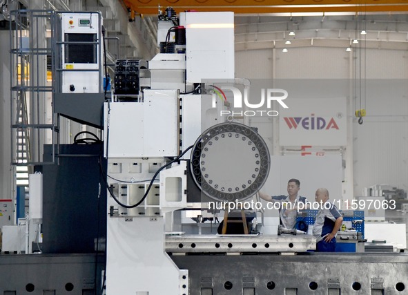 An employee debuts a CNC machine tool at an intelligent equipment company in Zaozhuang, China, on September 21, 2024. 