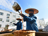 Workers stir soy sauce in Tengzhou, China, on September 21, 2024. (