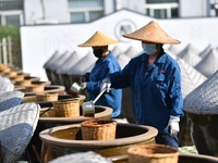 Workers stir soy sauce in Tengzhou, China, on September 21, 2024. (