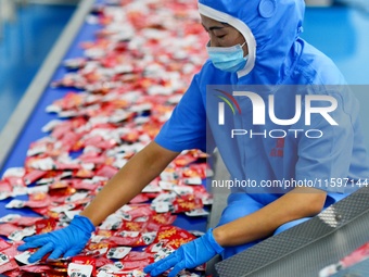 Workers inspect food packaging in Tengzhou, China, on September 21, 2024. (