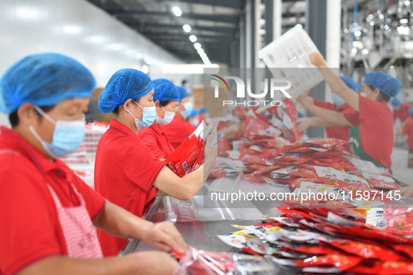 Workers inspect food in Tengzhou, China, on September 21, 2024. 