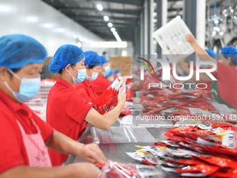 Workers inspect food in Tengzhou, China, on September 21, 2024. (