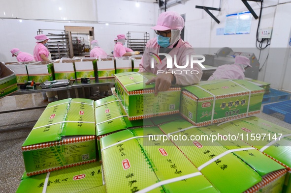 Workers pack food at a workshop in Tengzhou, China, on September 21, 2024. 