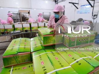 Workers pack food at a workshop in Tengzhou, China, on September 21, 2024. (