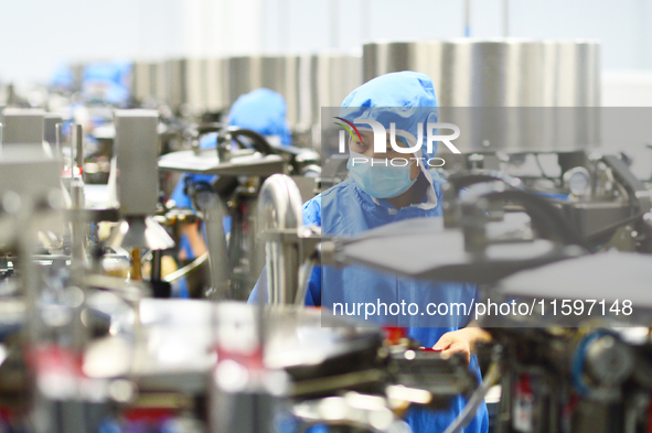 Workers operate in front of vacuum sealing machines in Tengzhou, China, on September 21, 2024. 