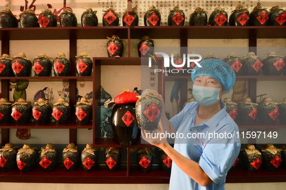 A worker shows a soy sauce packaging style in Tengzhou, China, on September 21, 2024. 