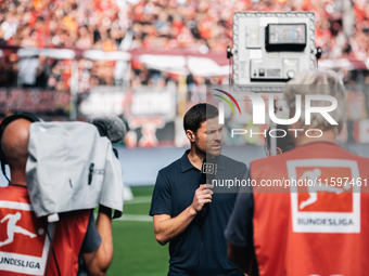 Xabi Alonso, Head Coach of Bayer 04 Leverkusen, does an interview prior to the Bundesliga match between Bayer 04 Leverkusen and VfL Wolfsbur...