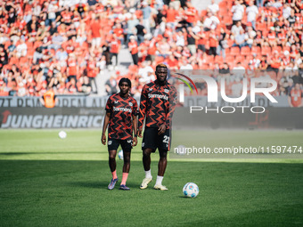 Jeremie Frimpong and Victor Boniface of Bayer 04 Leverkusen look on prior to the Bundesliga match between Bayer 04 Leverkusen and VfL Wolfsb...