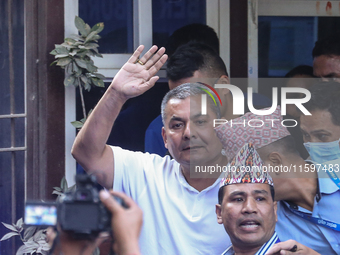 Medical entrepreneur Durga Prasai waves to the media and supporters after being arrested by the Nepal Police on charges of violating the Ele...