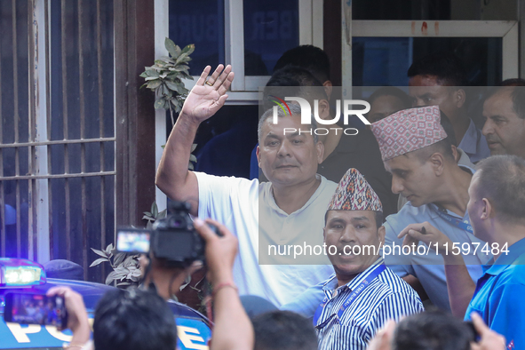 Medical entrepreneur Durga Prasai waves to the media and supporters after being arrested by the Nepal Police on charges of violating the Ele...