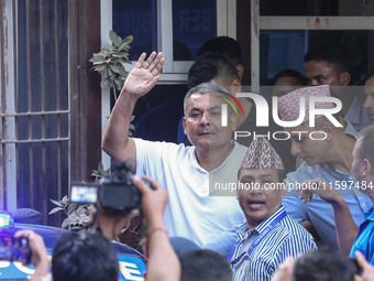 Medical entrepreneur Durga Prasai waves to the media and supporters after being arrested by the Nepal Police on charges of violating the Ele...