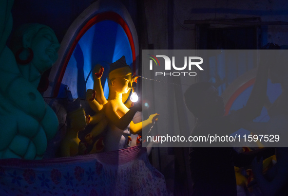 Idol makers dry a Durga idol with bulb light inside a workshop ahead of the Durga Puja festival in Kolkata, India, on September 22, 2024. 