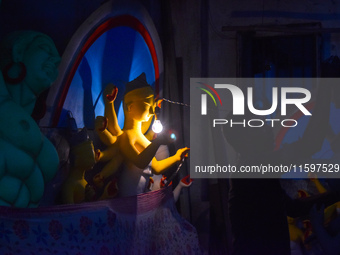 Idol makers dry a Durga idol with bulb light inside a workshop ahead of the Durga Puja festival in Kolkata, India, on September 22, 2024. (