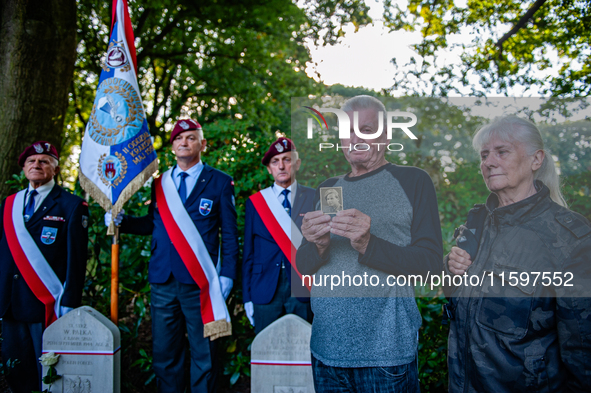 A son shows a photo of his father who fought in WWII during the Airborne Memorial Service held at War Cemetery in Oosterbeek, Netherlands, o...