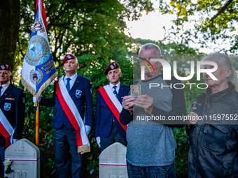 A son shows a photo of his father who fought in WWII during the Airborne Memorial Service held at War Cemetery in Oosterbeek, Netherlands, o...