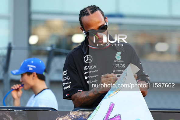 Lewis Hamilton of the United Kingdom and Mercedes-AMG Petronas F1 Team signs a poster during the drivers' parade ahead of the F1 Grand Prix...