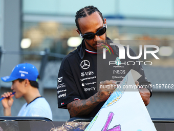 Lewis Hamilton of the United Kingdom and Mercedes-AMG Petronas F1 Team signs a poster during the drivers' parade ahead of the F1 Grand Prix...