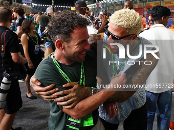 Fencer Miles Chamley-Watson (right) reacts on the grid ahead of the F1 Grand Prix of Singapore at Marina Bay Street Circuit in Singapore, Si...