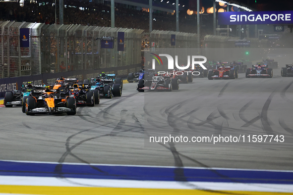 Lando Norris of the United Kingdom and McLaren Formula 1 Team drives on the opening lap during the F1 Grand Prix of Singapore at Marina Bay...