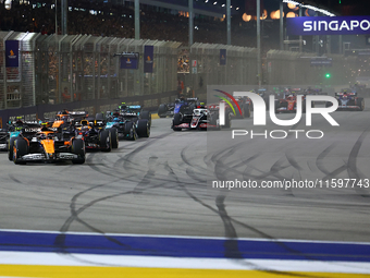 Lando Norris of the United Kingdom and McLaren Formula 1 Team drives on the opening lap during the F1 Grand Prix of Singapore at Marina Bay...