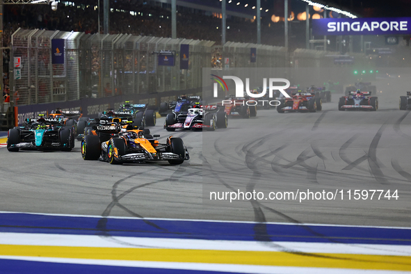 Lando Norris of the United Kingdom and McLaren Formula 1 Team drives on the opening lap during the F1 Grand Prix of Singapore at Marina Bay...