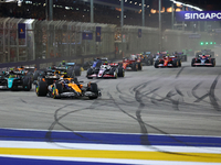 Lando Norris of the United Kingdom and McLaren Formula 1 Team drives on the opening lap during the F1 Grand Prix of Singapore at Marina Bay...