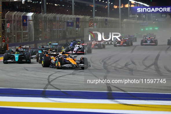 Lando Norris of the United Kingdom and McLaren Formula 1 Team drives on the opening lap during the F1 Grand Prix of Singapore at Marina Bay...